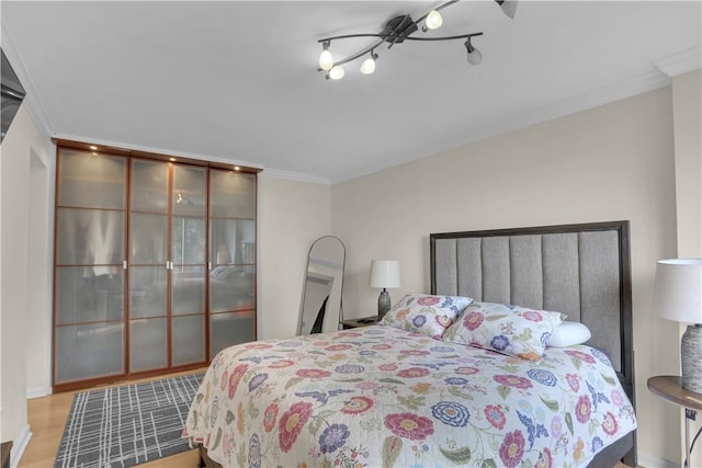 bedroom with light hardwood / wood-style floors and ornamental molding