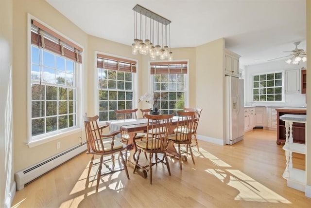 dining room featuring ceiling fan with notable chandelier, light hardwood / wood-style floors, and a baseboard radiator