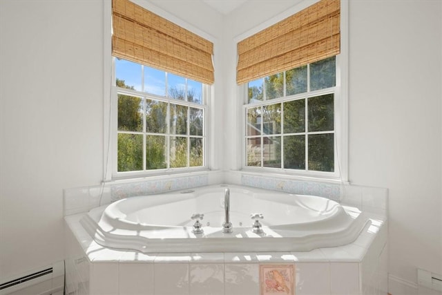 bathroom with tiled bath and a baseboard heating unit