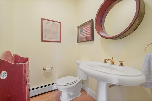 bathroom featuring hardwood / wood-style floors, a baseboard radiator, and toilet