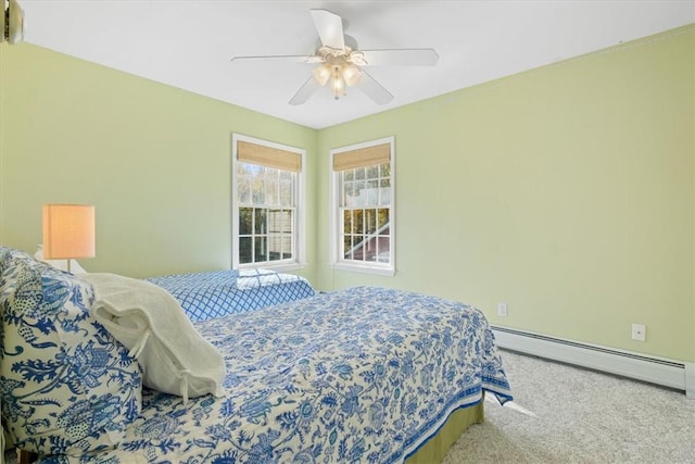 carpeted bedroom with ceiling fan and a baseboard heating unit