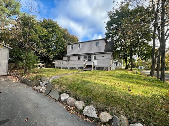 rear view of house with a lawn and a wooden deck