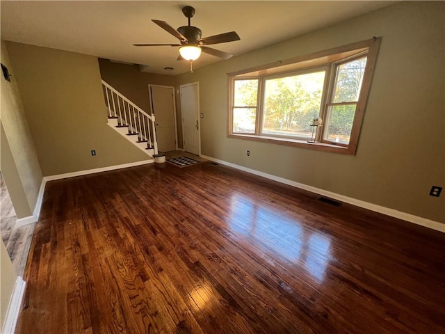 unfurnished living room with dark hardwood / wood-style floors and ceiling fan