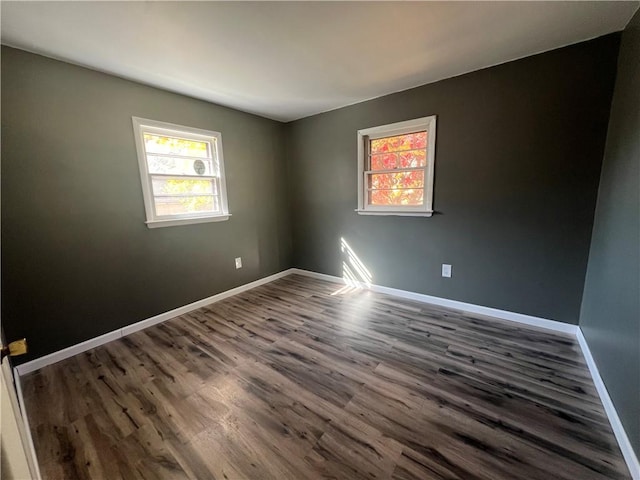 empty room with dark hardwood / wood-style flooring