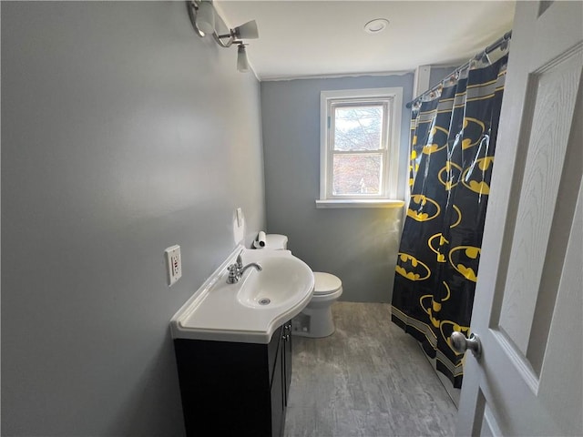 bathroom with hardwood / wood-style floors, vanity, and toilet