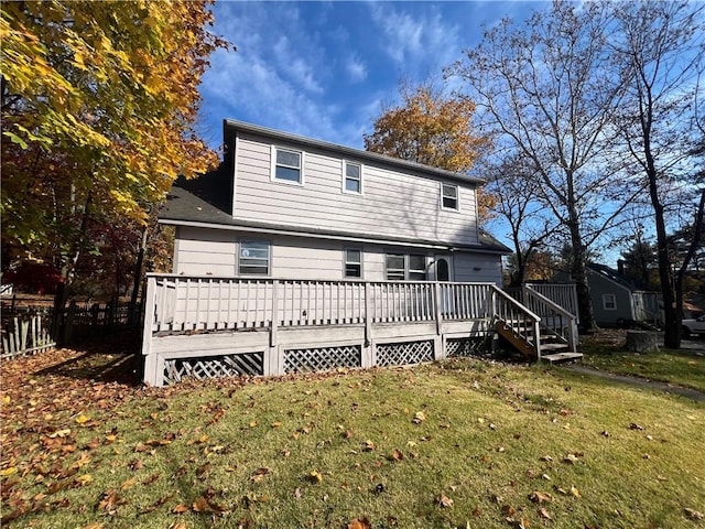 rear view of house featuring a yard and a wooden deck