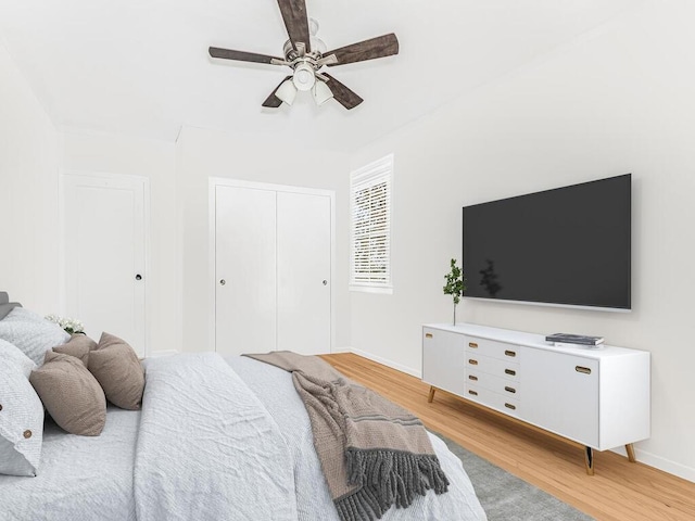 bedroom with ceiling fan, light wood-type flooring, and a closet