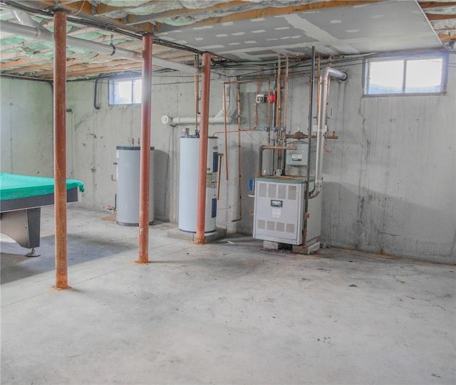 basement featuring electric water heater, plenty of natural light, and water heater