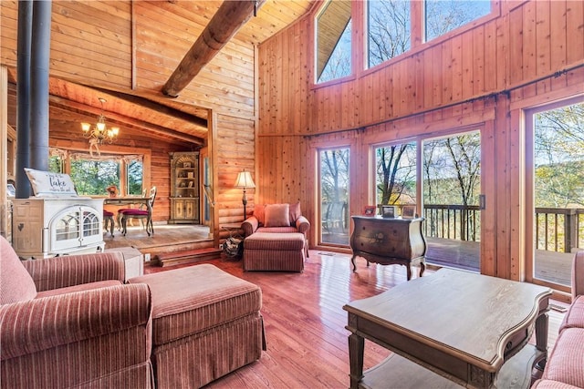 living room featuring beamed ceiling, high vaulted ceiling, light hardwood / wood-style floors, and a wealth of natural light