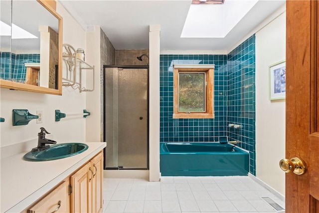 bathroom with tile patterned floors, vanity, independent shower and bath, and a skylight