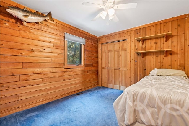 carpeted bedroom featuring ceiling fan, wooden walls, and a closet