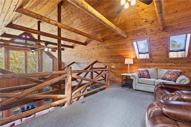 living room with beamed ceiling, wood walls, carpet floors, and a skylight