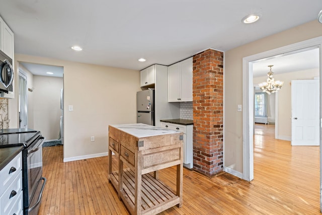 kitchen with white cabinets, stainless steel appliances, and light hardwood / wood-style flooring