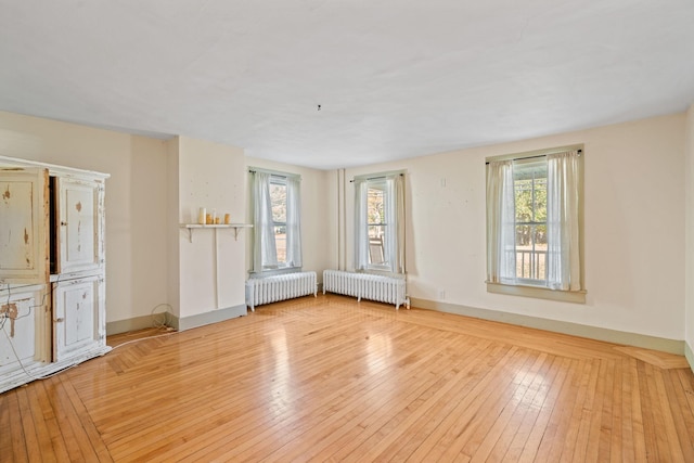 empty room with light hardwood / wood-style floors and radiator