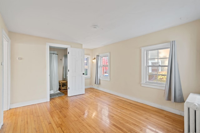 unfurnished bedroom featuring radiator and light wood-type flooring