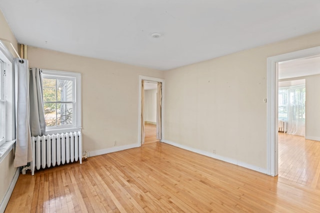 unfurnished room featuring light wood-type flooring and radiator