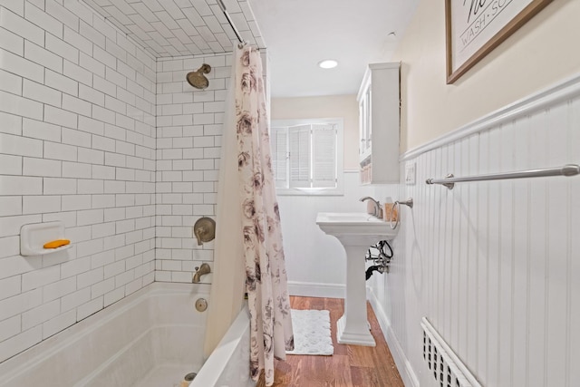 bathroom with hardwood / wood-style floors and shower / bath combination with curtain