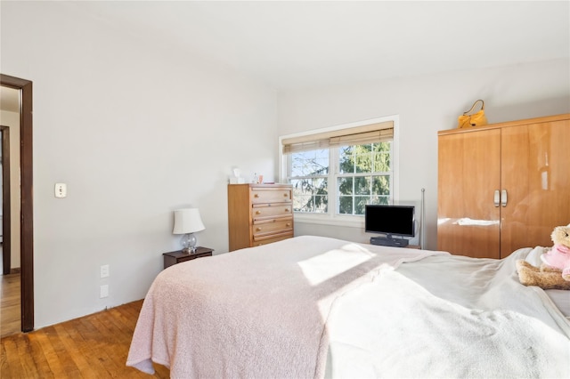 bedroom with light hardwood / wood-style flooring and lofted ceiling