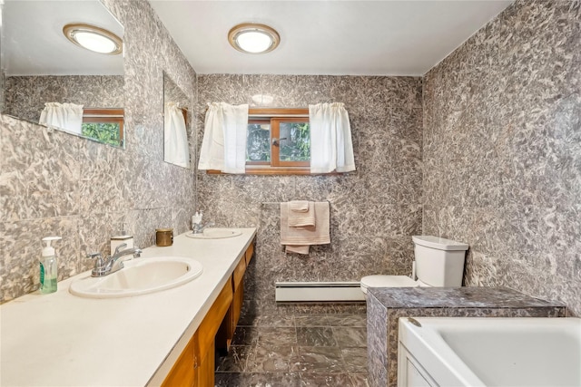 bathroom featuring vanity, toilet, baseboard heating, and a healthy amount of sunlight