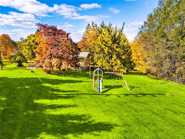 view of property's community with a playground and a yard