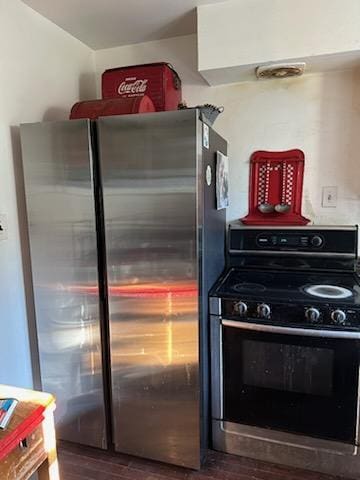 kitchen featuring electric range, freestanding refrigerator, and dark wood-type flooring