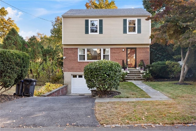 front of property featuring a front yard and a garage