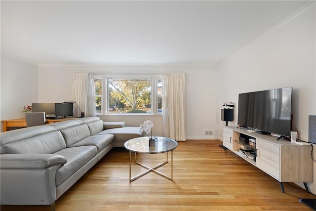 living room featuring ornamental molding and light wood-type flooring