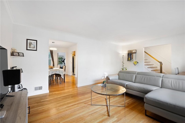 living room with light hardwood / wood-style flooring and ornamental molding