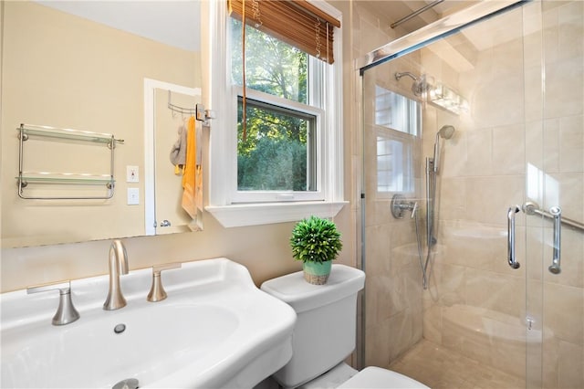 bathroom with walk in shower, sink, and toilet