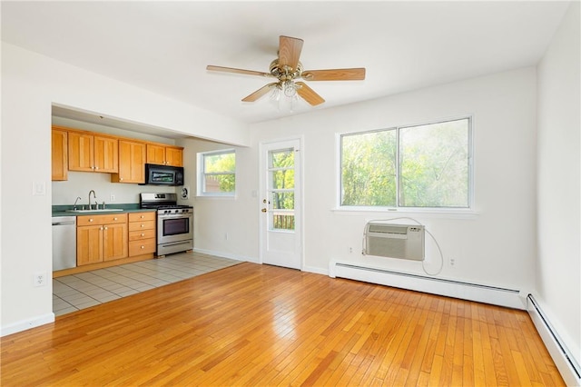 kitchen featuring sink, a baseboard radiator, light hardwood / wood-style floors, stainless steel appliances, and a wall unit AC