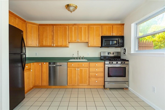 kitchen with sink, light tile patterned floors, and black appliances