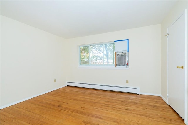 empty room with light wood-type flooring and a baseboard heating unit