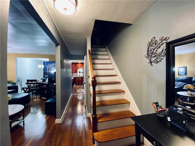 staircase featuring hardwood / wood-style floors and an inviting chandelier