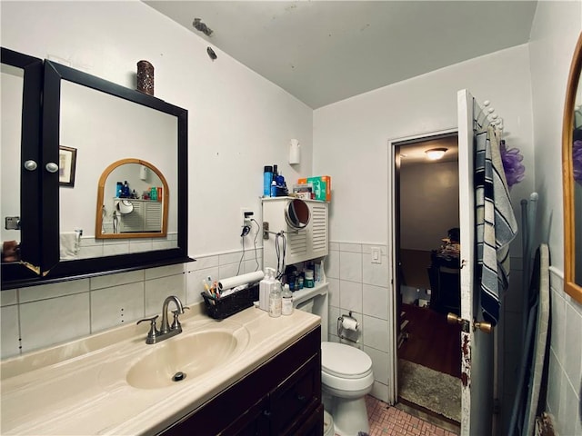 bathroom featuring vanity, toilet, and tile walls