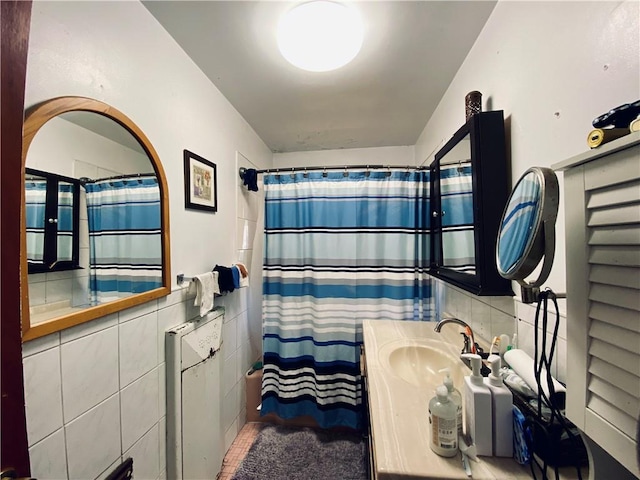 bathroom featuring vanity and tile walls