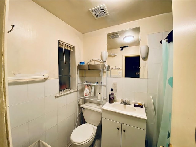 bathroom with decorative backsplash, vanity, toilet, and tile walls