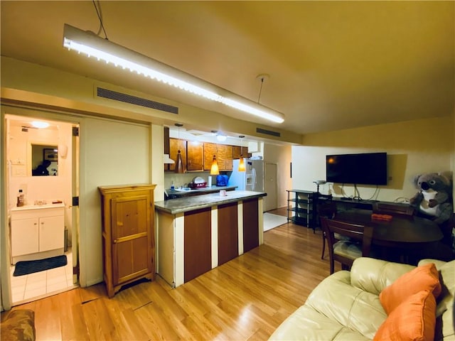 kitchen with white fridge with ice dispenser and light hardwood / wood-style floors