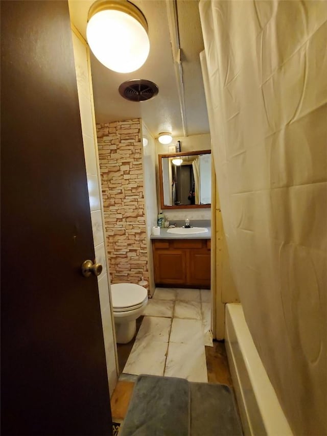 full bathroom with shower / tub combo, vanity, and toilet