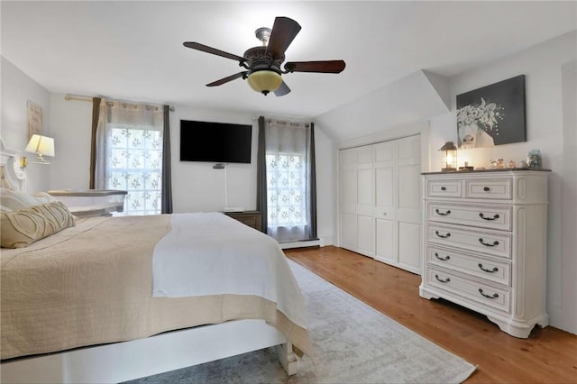 bedroom featuring hardwood / wood-style flooring, ceiling fan, lofted ceiling, and a closet