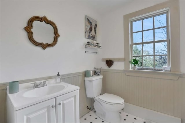 bathroom with vanity, wood walls, and toilet