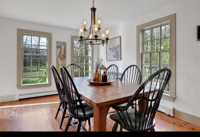 dining room with a notable chandelier, light wood-type flooring, and a baseboard radiator