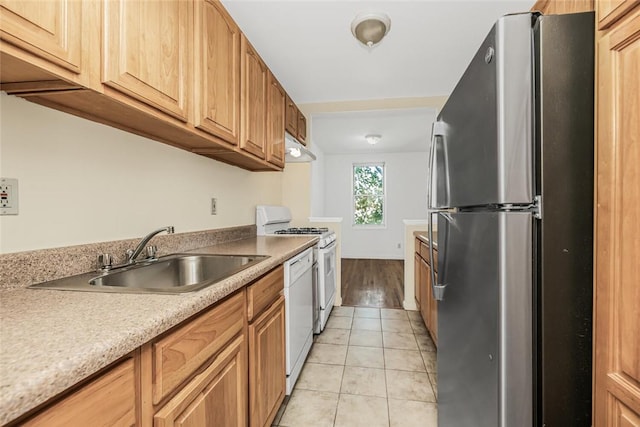 kitchen with sink, light tile patterned floors, and white appliances