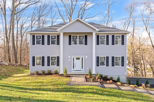 colonial home featuring a front lawn