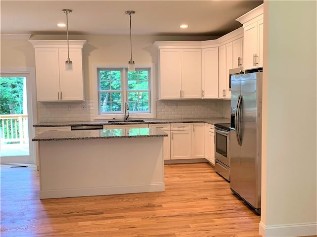 kitchen featuring pendant lighting, white cabinets, stainless steel appliances, and sink