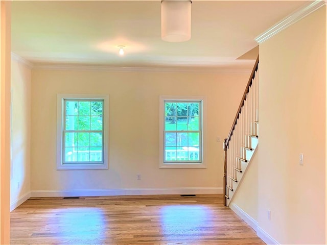 unfurnished room featuring plenty of natural light, light wood-type flooring, and ornamental molding