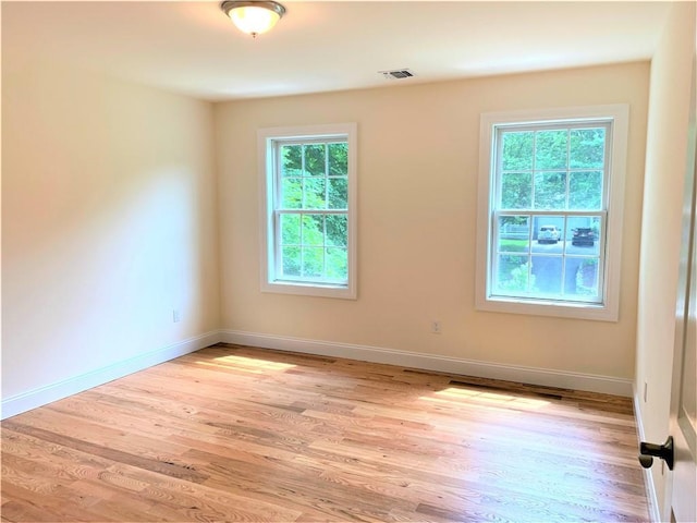 unfurnished room featuring plenty of natural light and light hardwood / wood-style floors