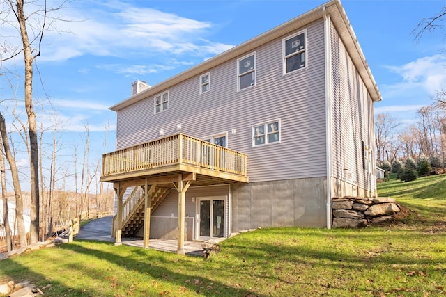 rear view of house featuring a lawn and a wooden deck