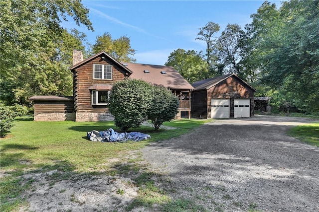 view of front of home featuring an outbuilding, a garage, and a front lawn