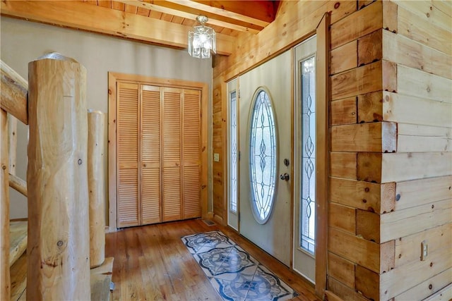 foyer with beamed ceiling and wood-type flooring