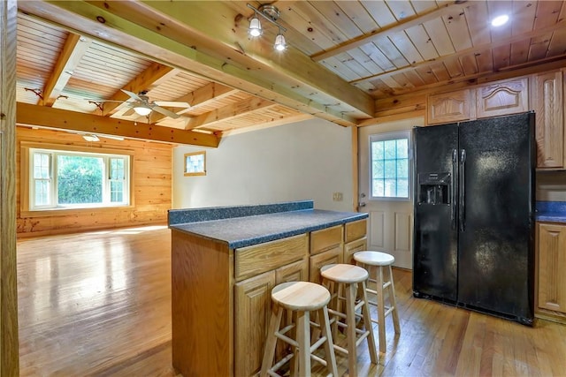 kitchen featuring light hardwood / wood-style floors, black fridge with ice dispenser, wood ceiling, and a wealth of natural light